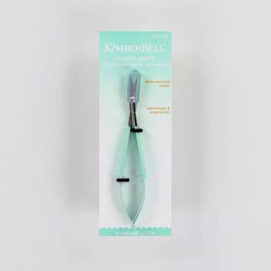 May include: A pair of Kimberbell Sharp Snips on a white background. The snips have a light blue handle and blade, with a micro-serrated blade. The packaging includes the text "Sharp Snips" and "Lightweight & ergonomic."