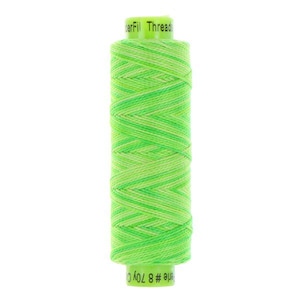 May include: A spool of WonderFil Threads featuring a vibrant variegated pattern of lime green and yellow thread wound in a cross-stitch style. The top and bottom labels are light green with black text reading WonderFil Threads and Perle # 8 70y Co.