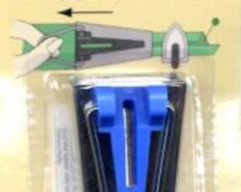 May include: A blue bias tape maker with a clear plastic case. The tool is used to create bias tape for sewing projects. The packaging includes instructions in multiple languages.