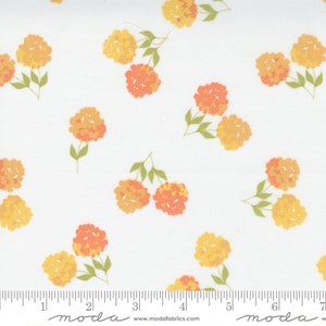 May include: White fabric with a repeating pattern of orange and yellow floral clusters. The flowers have a textured appearance and are set against a clean white background. Green stems and leaves accompany the blooms.