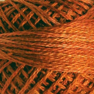 May include: A spool of embroidery floss in a deep orange color.