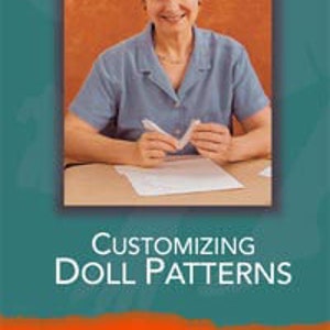 Puede incluir: Una mujer sonríe mientras está sentada en una mesa y sostiene una pluma y papel. El texto en la portada dice "Antoinette Cely's Customizing Doll Patterns" y "Your first step in creating beautiful dolls."