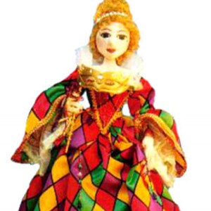 Pode incluir: Uma boneca feita à mão vestindo um vestido xadrez colorido com detalhes dourados. A boneca tem cabelo loiro e uma coroa.