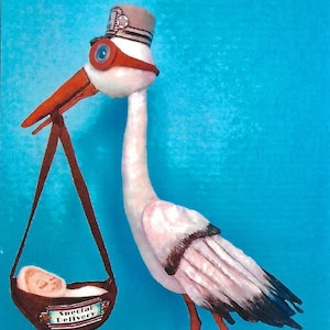 Puede incluir: Una cigüeña blanca con un sombrero marrón y gafas rojas lleva una cuna marrón con un bebé dentro. La cuna tiene un letrero que dice "Entrega especial".