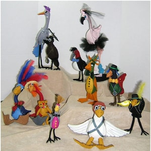 Puede incluir: Una colección de 10 figuritas de pájaros de fieltro hechas a mano. Los pájaros son de diferentes colores y tienen detalles únicos, como sombreros, plumas y lazos.