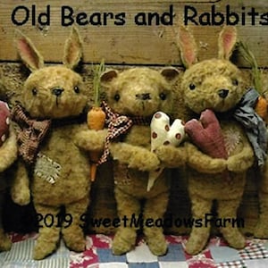 Puede incluir: Cinco juguetes de peluche hechos a mano, incluyendo dos conejos marrones y tres osos marrones, sosteniendo corazones y zanahorias. Los juguetes están dispuestos sobre una tela a cuadros. El texto "Old Bears and Rabbits" se muestra encima de los juguetes. El texto "2019 Sweet Meadows Farm" se muestra debajo de los juguetes.