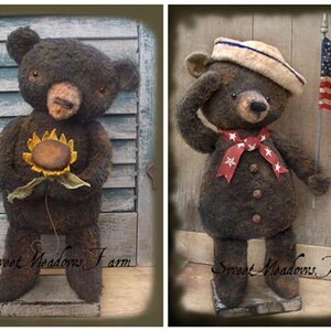 Puede incluir: Dos osos de peluche hechos a mano de estilo primitivo. El oso de la izquierda sostiene un girasol y el oso de la derecha sostiene una bandera estadounidense. Ambos osos están de pie sobre bases de madera. El texto "Sweet Meadows Farm" es visible en ambos lados de la imagen.
