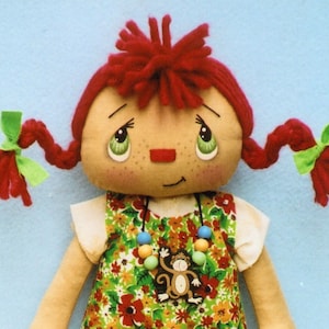 May include: A handmade rag doll with red yarn hair in pigtails with green bows. The doll is wearing a floral print dress with a beaded necklace and a monkey charm.