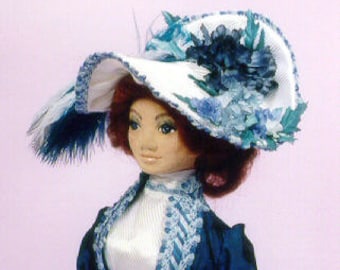 May include: A white hat with a wide brim and blue floral embellishments. The hat is trimmed with a blue ribbon and a white feather.