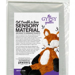 May include: A package of 36 by 51 inch cut crackle and sew sensory material. The package is white and has a fox plush toy on the front. The text on the package reads "Cut Crackle & Sew Sensory Material" and "The Gypsy Quilter".
