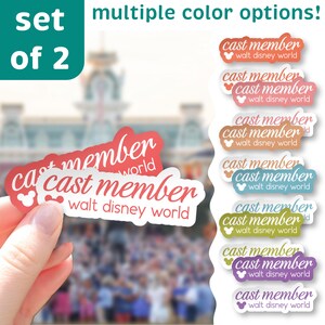 May include: A set of two stickers with the text "cast member walt disney world" in a stylized font. The stickers are red with white text and a Mickey Mouse icon. Additional stickers in various colors are also shown.