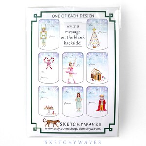 May include: A sheet of nine Christmas gift tags with a variety of illustrations, including a nutcracker, a ballerina, a gingerbread house, a Christmas tree, a stack of cupcakes, a girl in a blue dress, and a king in a red robe. The tags are printed on white cardstock with a light blue background and snowflakes. The text "ONE OF EACH DESIGN" and "write a message on the blank backside!" is printed at the top of the sheet. The text "SKETCHYWAVES" is printed at the bottom of the sheet.
