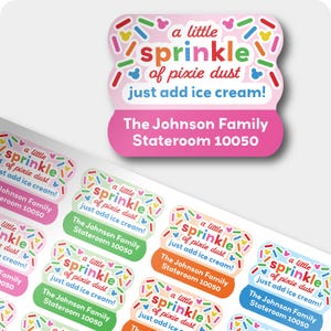 Puede incluir: Una hoja de pegatinas coloridas con el texto "a little sprinkle of pixie dust just add ice cream!" y "The Johnson Family Stateroom 10050". Las pegatinas tienen un fondo rosa, verde, naranja y azul con chispas coloridas.