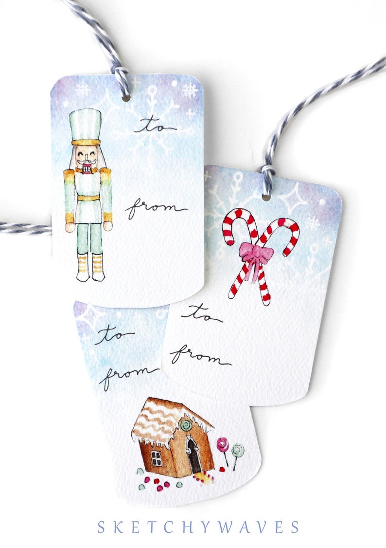 May include: Three watercolor Christmas gift tags with blue and white backgrounds. The first tag features a nutcracker, the second tag features candy canes, and the third tag features a gingerbread house. Each tag has the words "to" and "from" written on them.