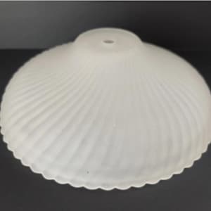 May include: A circular, frosted glass lamp shade featuring a scalloped edge and a delicate, radiating ribbed pattern that extends from the center opening toward the outer rim, creating a soft, translucent appearance for light diffusion.