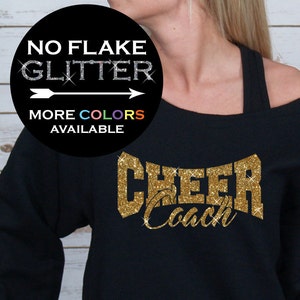 May include: Black sweatshirt with a gold glitter design that says "Cheer Coach".