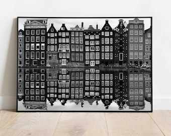 Könnte beinhalten: Schwarzweißfoto einer Reihe traditioneller holländischer Grachtenhäuser, die sich im Wasser spiegeln. Die Häuser haben viele Fenster und sind in einer Reihe angeordnet.