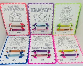 May include: Six colourful Valentine's Day cards with colouring pages and a slot for crayons. The cards feature images of a watermelon, a unicorn, a frog, a rocket, cupcakes and rainbows, and a rainbow with hearts. The text on the cards includes "You are one in a melon", "Wishing you a magical Valentine's Day", "Hoppy Valentine's Day", "Out of this world", "Cupcakes & Rainbows", and "XOXO".