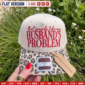 May include: A cream-colored baseball cap with a leopard print brim. The front features red embroidered text that reads, "that sounds like my HUSBAND'S PROBLEM." A rectangular tag on the brim displays "OTTO CLASSIC FIT OSPM."