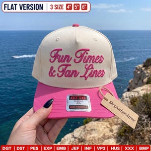 Op de afbeelding: Een crèmekleurige baseballpet met een roze klep en roze geborduurde tekst Fun Times & Tan Lines. De pet heeft een Otto-sticker op de klep en een beige kartonnen label aan een touwtje, met de beschikbare maten van 10, 13 en 15 cm.