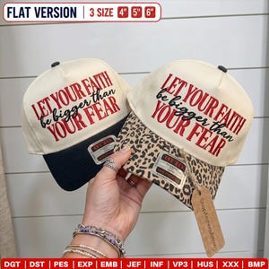 May include: Two baseball caps with cream-coloured crowns and embroidered red and black text reading LET YOUR FAITH be bigger than YOUR FEAR. One cap has a solid black brim, the other a leopard print brim. Both feature Otto brand stickers.