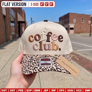 May include: A cream-coloured baseball cap with a leopard print brim. The front features embroidered text reading coffee club in various shades of brown and tan. A rectangular tag attached with twine reads ShopArchersArrow. The brim shows 10, 13, 15 cm sizes.