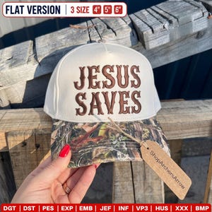 Könnte beinhalten: Eine cremefarbene Baseballkappe mit einem Schirm im Camouflage-Muster. Auf der Vorderseite befindet sich der braun gestickte Schriftzug "JESUS SAVES". Ein braunes Pappschild am Schirm zeigt den Text "ShopArchersArrow" in schwarzer Schrift.