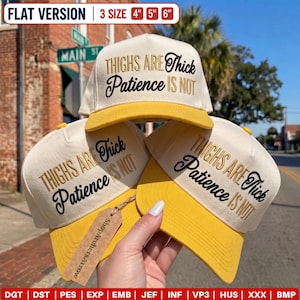 May include: Three cream-coloured baseball caps with yellow brims, each featuring the embroidered text "THIGHS ARE Thick Patience IS NOT" in black and gold. A brown rectangular tag with the text "ShopArchersArrow" is attached to one cap.
