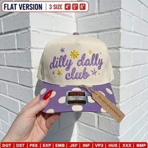 May include: A cream-colored baseball cap with a purple polka dot brim. The front features purple embroidered text reading "dilly dally club" surrounded by small yellow and purple star and flower icons. An Otto brand sticker is on the brim.
