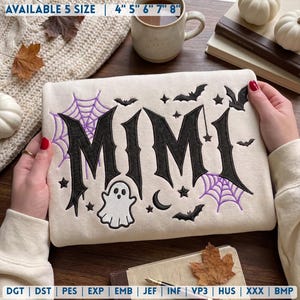 May include: A cream-colored fabric item featuring black embroidered text that reads MIMI in a gothic font. The design includes purple spider webs, black bats, a white ghost, stars, and a crescent moon. Text at the top reads AVAILABLE 5 SIZE 4" 5" 6" 7" 8".