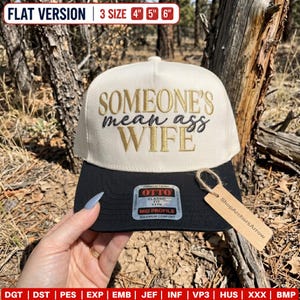 May include: A cream-colored baseball cap with a black brim featuring the embroidered text "SOMEONE'S mean ass WIFE" in gold and black. The cap includes an Otto brand sticker on the brim and a brown cardboard tag labeled ShopArchersArrow.