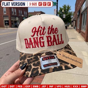 Könnte beinhalten: Eine cremefarbene Baseballkappe mit einem Schirm im Leopardenmuster. Auf der Vorderseite befindet sich ein roter Stickschriftzug mit dem Text Hit the DANG BALL. Ein braunes Pappetikett am Schirm zeigt ShopArchersArrow. Ein Aufkleber weist auf die Größen 4, 5 und 6 Zoll hin.
