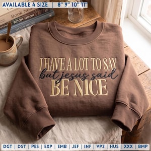May include: A brown crewneck sweatshirt featuring embroidered text that reads I HAVE A LOT TO SAY but jesus said BE NICE. The sweatshirt has long sleeves with ribbed cuffs and a ribbed neckline, showcasing a clean, solid-colored fabric design.