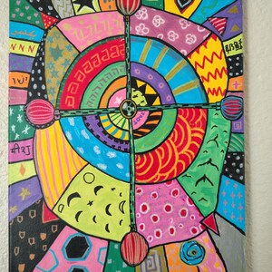 May include: A rectangular canvas painting featuring a vibrant, multi-colored abstract design with concentric circles and a central cross-shaped element. The artwork includes various patterns like stars, moons, and geometric shapes in bright hues.