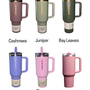 May include: Six Stanley Quencher tumblers in various colors: Cashmere, Juniper, Bay Leaves, Hydrangea, Cherry Blossom, and Port Shimmer. Each tumbler has a handle, a straw, and the Stanley logo. The tumblers are designed for beverages.