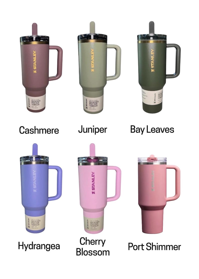 May include: Six Stanley Quencher tumblers in various colors: Cashmere, Juniper, Bay Leaves, Hydrangea, Cherry Blossom, and Port Shimmer. Each tumbler has a handle, a straw, and the Stanley logo. The tumblers are designed for beverages.