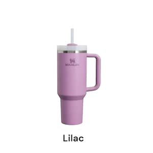 May include: A lilac-colored Stanley tumbler with a handle and a white lid and straw. The Stanley logo is visible on the side. The word "Lilac" is written in a black font at the bottom of the image.