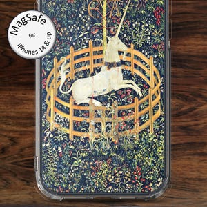 May include: Clear phone case featuring a detailed tapestry design with a white unicorn inside a wooden fence. The background is a dark blue with floral and foliage patterns. The case has the text "MagSafe for iPhones 14 & up".