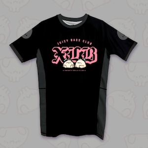 Puede incluir: Una camiseta negra de manga corta con paneles laterales de color gris oscuro. El frente presenta un texto rosa de estilo gótico que dice JUICY BAOS CLUB y JBC, acompañado de dos pequeñas ilustraciones de dumplings sonrientes y el texto SWEATY ROLLS CLUB.