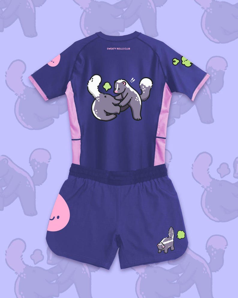 May include: A navy blue athletic set featuring a short-sleeved shirt and shorts. The shirt and shorts have pink accents and cartoon skunk graphics. The shirt has the text "SWEATY ROLLS CLUB" on the back.