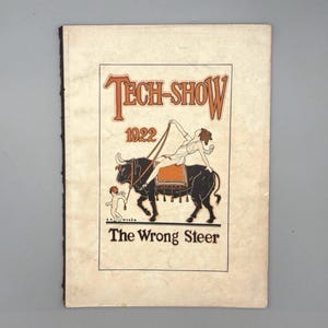 Pode incluir: Cartaz vintage "Tech-Show 1922". O cartaz apresenta um touro preto com uma pessoa montada, e uma pequena figura. O texto "Tech-Show" é laranja e o texto "The Wrong Steer" está abaixo do touro.