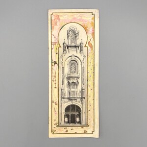 May include: An antique postcard with a black and white illustration of a building facade, showcasing intricate architectural details. The postcard has a decorative border with pink and gold accents, and a peacock illustration.