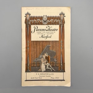 May include: A vintage advertisement for Parsons Theatre in Hartford, Connecticut. The ad features a couple standing in front of a grand piano, with a street lamp on either side. The text reads "Parsons Theatre Under the Direction of Lee and J.J. Shubert Hartford".