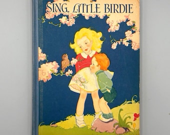May include: Vintage children's book titled "Sing, Little Birdie." The cover features an illustration of two children, a girl in a red top and a boy in a green jacket, with a bird perched on a flowering branch. The background is a deep blue.