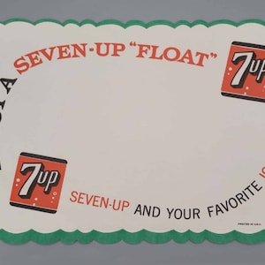 Könnte beinhalten: Ein weißer Papier-Tischuntersetzer mit grünem, gewelltem Rand. Der Tischuntersetzer zeigt den Text "ENJOY A SEVEN-UP "FLOAT" SEVEN-UP AND YOUR FAVORITE ICE CREAM!" und zwei rote und orangefarbene 7Up-Logos.