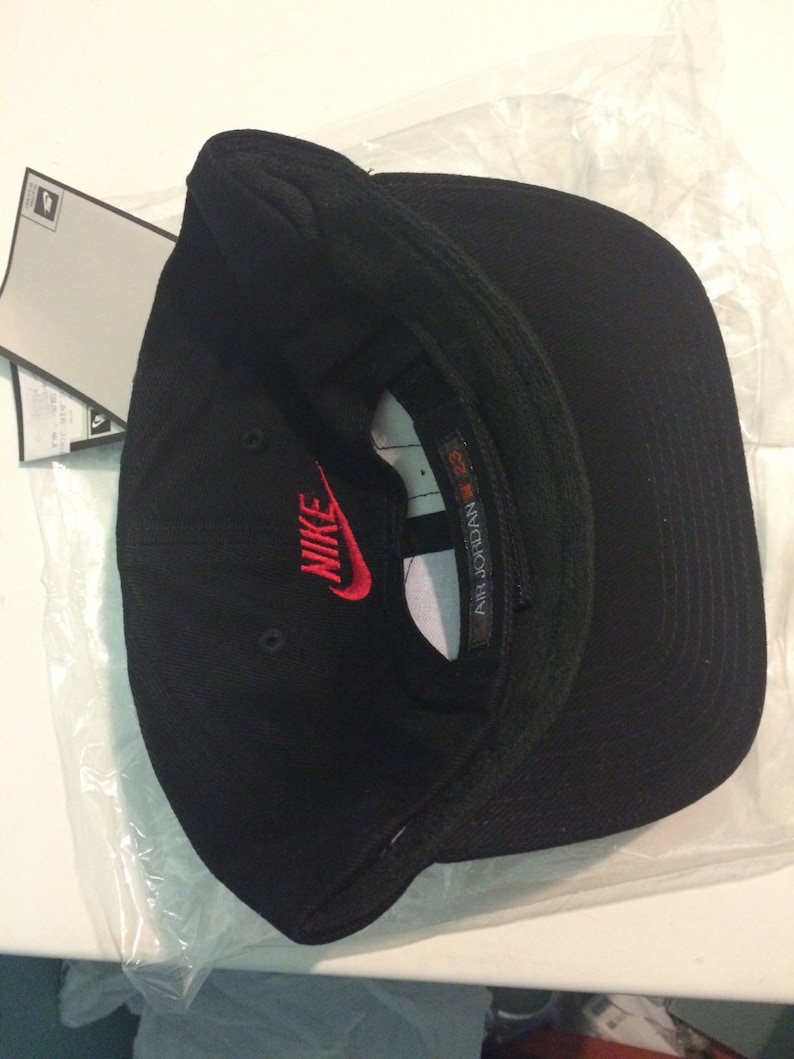 May include: Black baseball cap with a red Nike logo and the text "AIR JORDAN" on the side.