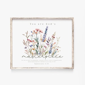 Puede incluir: Impresión enmarcada con las palabras "You are God's masterpiece" sobre un arreglo floral en acuarela. La impresión incluye el versículo bíblico Efesios 2:10.