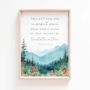 May include: A framed art print featuring a watercolor landscape with mountains, trees, and flowers. The artwork includes the text "Thou wilt keep him in perfect peace..." from Isaiah 26:3. The frame is a light wood color.