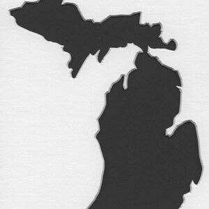 May include: A black silhouette of the state of Michigan. The outline of the state is cut out of a white background.