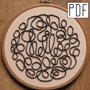 May include: A circular wooden embroidery hoop containing light beige fabric with a black beaded design forming the word hello in a continuous cursive script. The beads are interspersed with small metallic gold accents. A white box with PDF text.